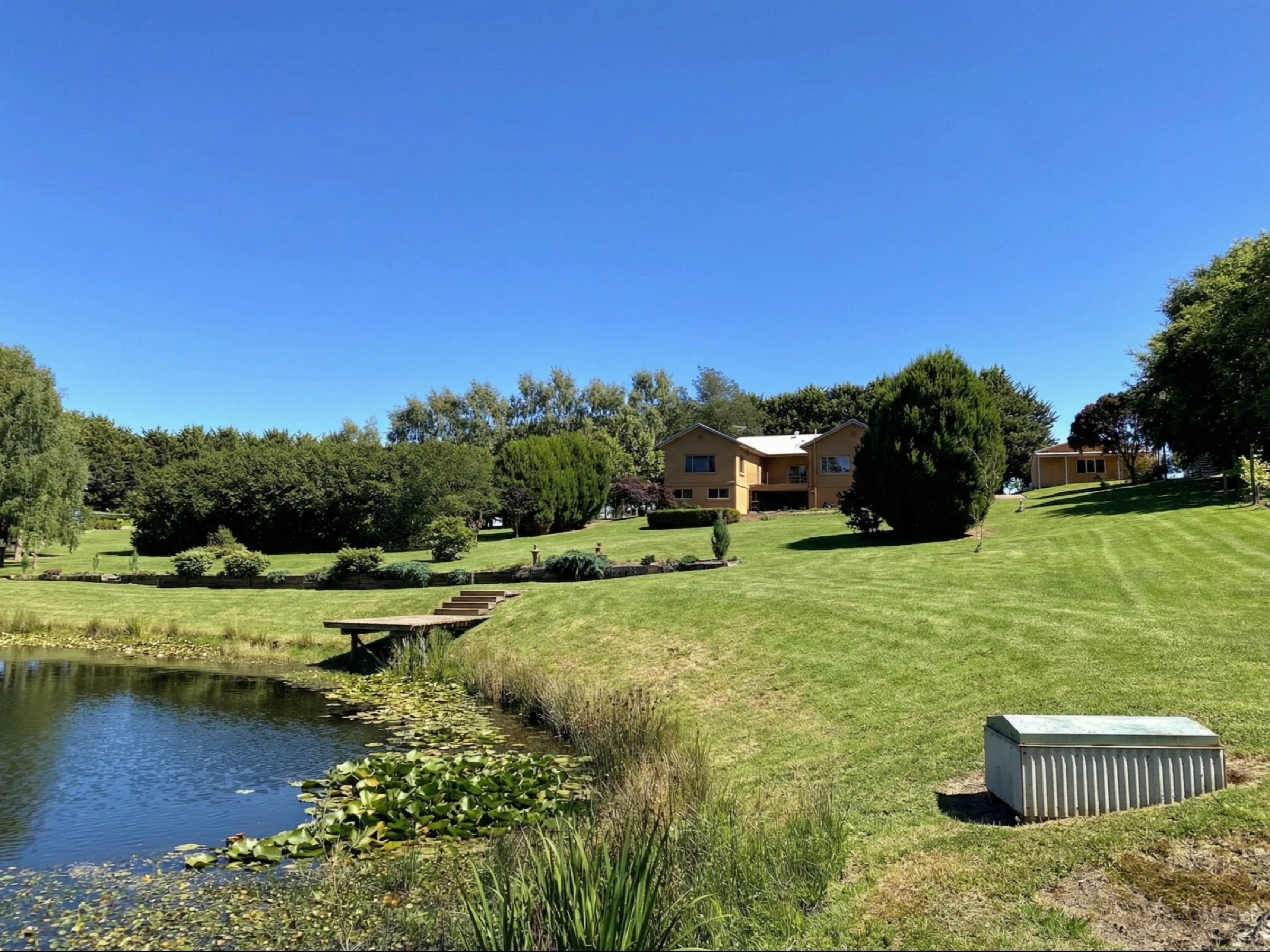 Acreage benchmark property with water feature and lawns